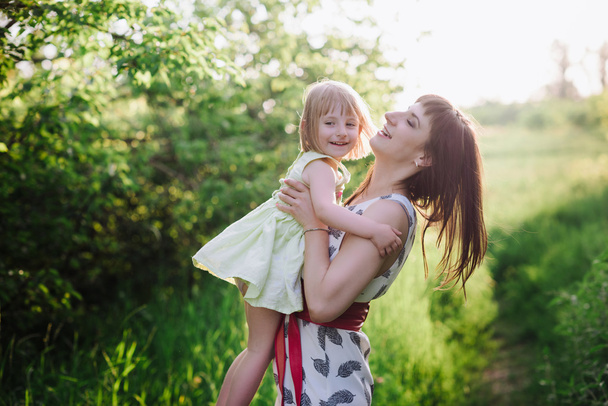 Mom and daughter dancing in nature together in sunset light - Photo, Image