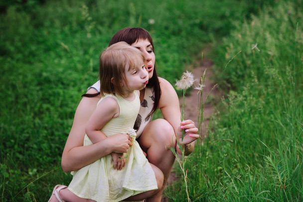 Mom kisses and hugs daughter on nature - Photo, Image