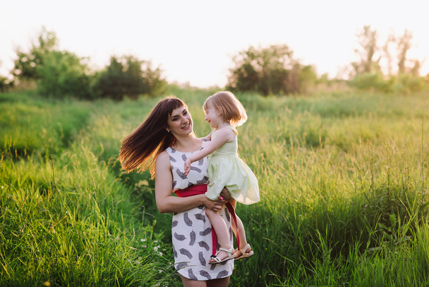 Mom and daughter dancing in nature together in sunset light - Foto, Imagen