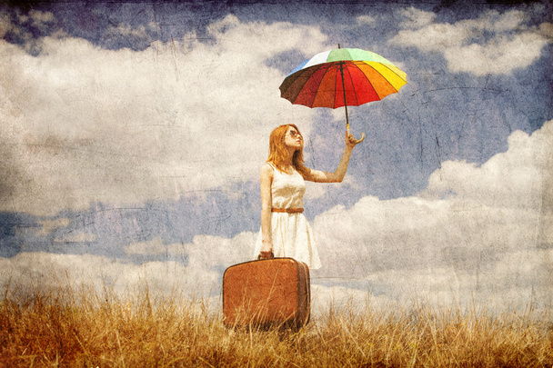 Beautiful redhead girl with umbrella and suitcase at outdoor. - Photo, Image