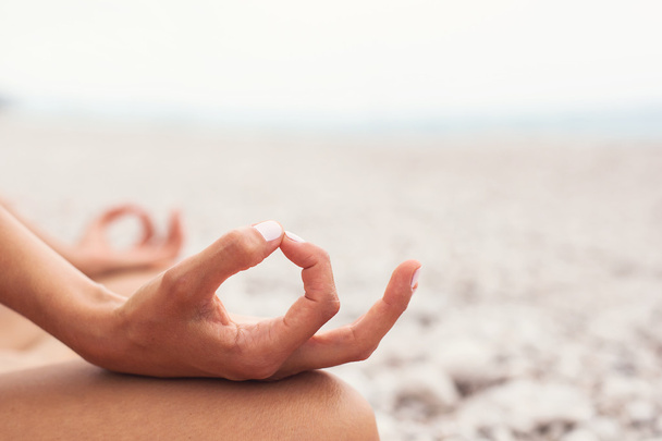 Meditating. Woman doing yoga. Close-up - Фото, изображение