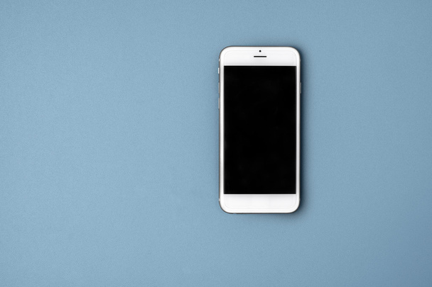 Teléfono inteligente en blanco sobre fondo azul
 - Foto, imagen