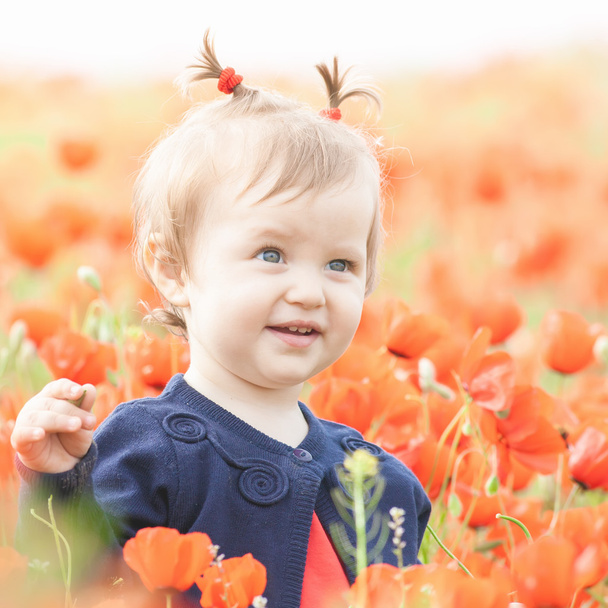 Funny child holding a balloon outdoor at poppy field - Фото, зображення