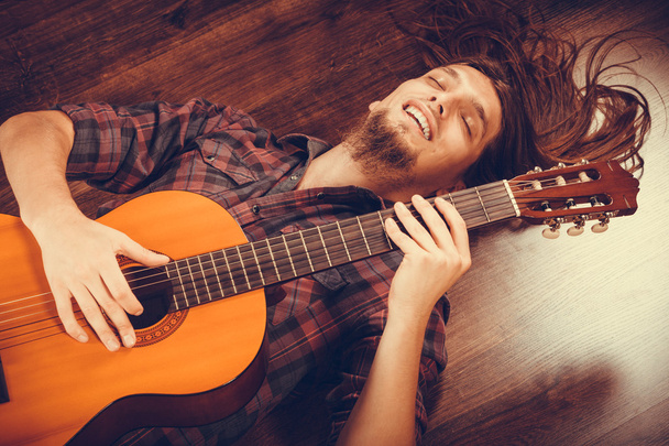 Smiled male with wooden guitar. - Fotoğraf, Görsel