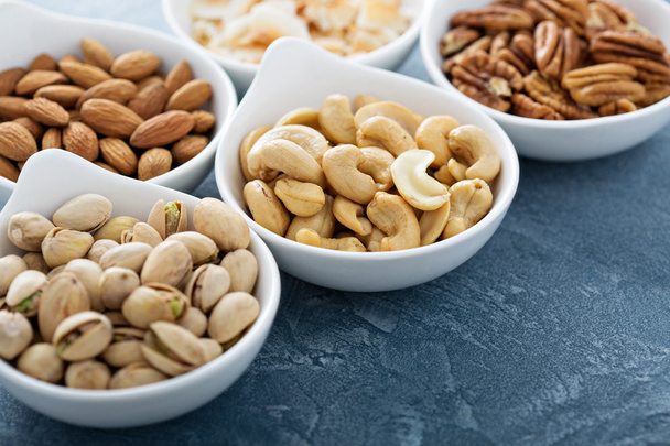 Variety of nuts in small bowls - Valokuva, kuva