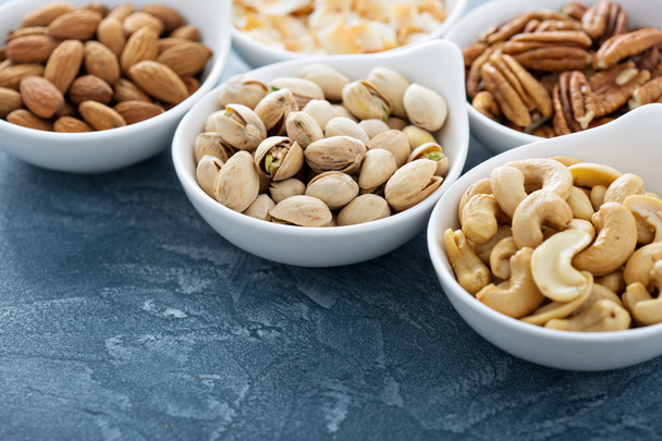Variety of nuts in small bowls - Valokuva, kuva