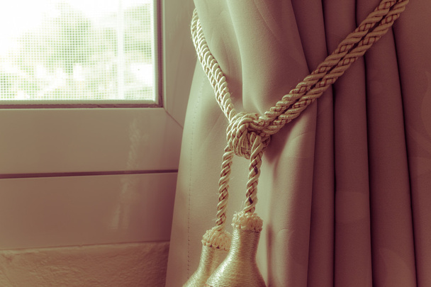 Rideaux pompon avec corde par la fenêtre à gauche, style rétro vintage
. - Photo, image
