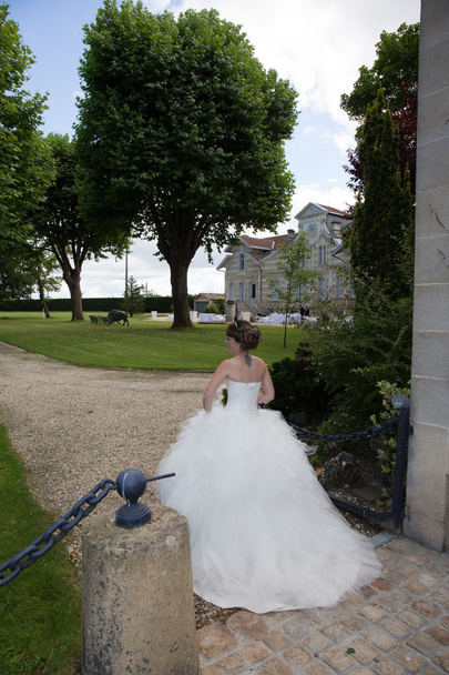 Vue arrière de la belle jeune mariée à l'extérieur du château marchant
 - Photo, image