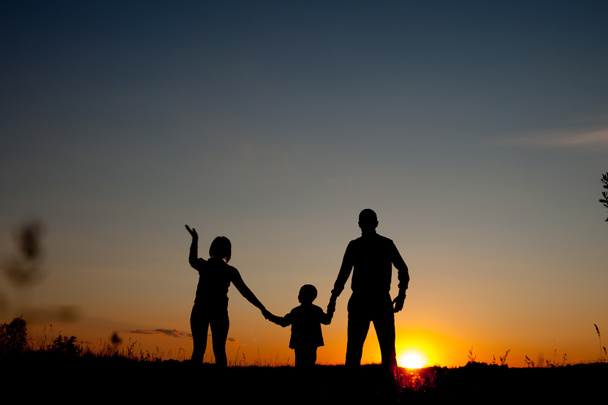 Boldog családi állt a park naplemente idején. A barátságos családi fogalmát. - Fotó, kép