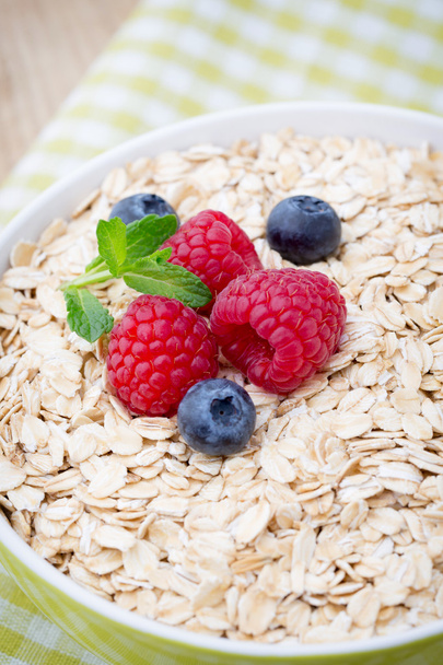 Oatmeal porridge with berries. Raspberries and blueberries. - Photo, Image