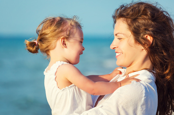 Happy mother and daughter on the beach - Photo, image