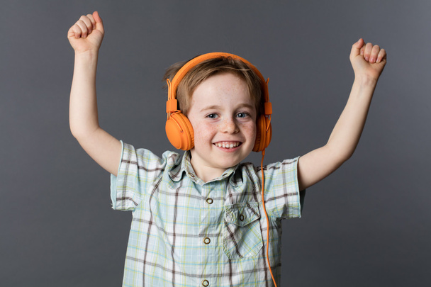 excited young kid enjoying listening to music on headphones - Photo, Image