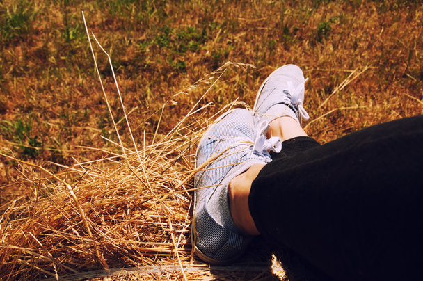 Ženské nohy s modré boty sedí na balíku - Fotografie, Obrázek