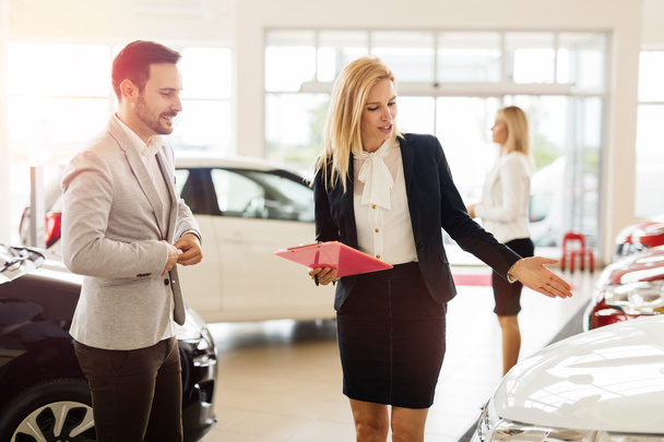 Salesperson showing vehicle to potential customer - Zdjęcie, obraz