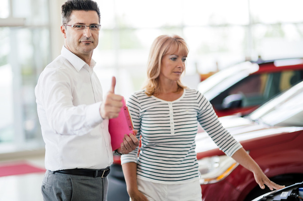 Customer looking at cars at dealership - Foto, imagen