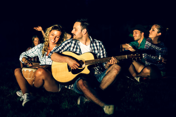 Friends enjoying music near campfire - Fotografie, Obrázek
