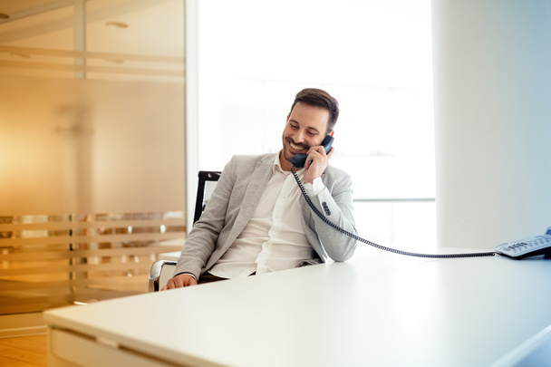Businessman using talking on phone in office - Фото, зображення