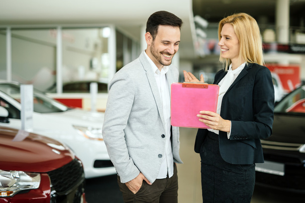 Salesperson showing vehicle to potential customer - Zdjęcie, obraz