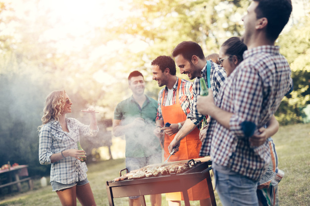 Friends having a barbecue party in nature - Foto, immagini