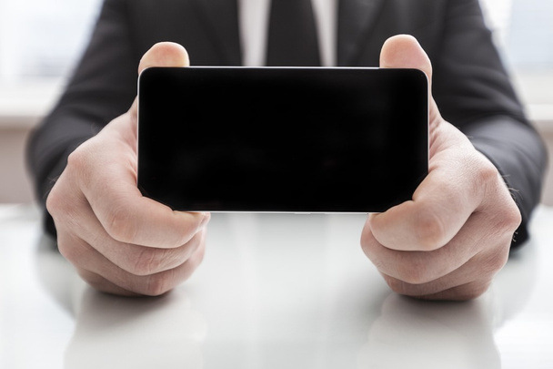 Businessman showing smart phone - Foto, Imagen