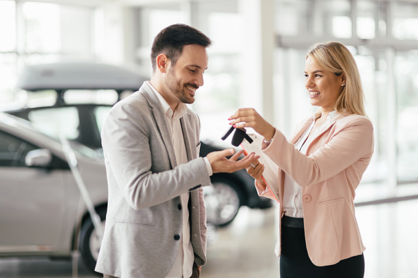 Customer buying a car at dealership - Фото, зображення
