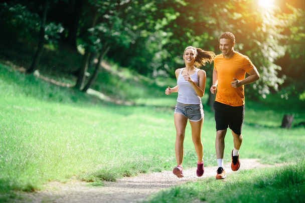 Healthy couple jogging in nature - Фото, изображение