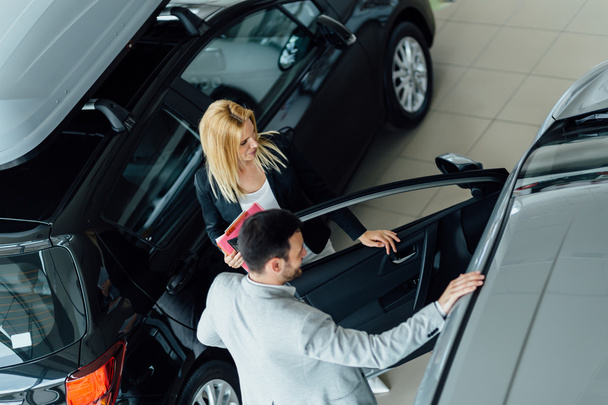 Customer looking for a car at dealership - 写真・画像