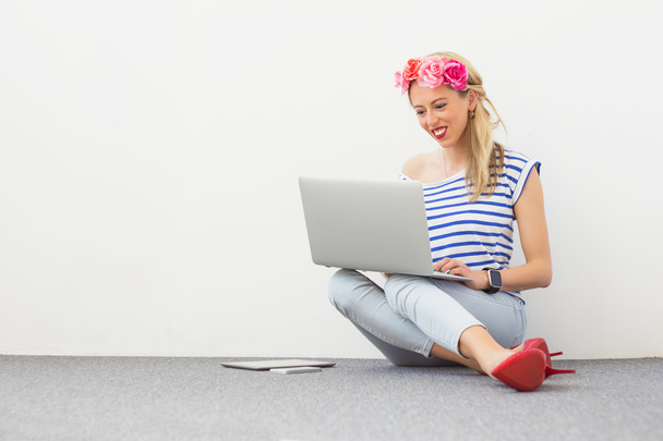 Muoti bloggaaja istuu lattialla ja kannettavan tietokoneen avulla
 - Valokuva, kuva