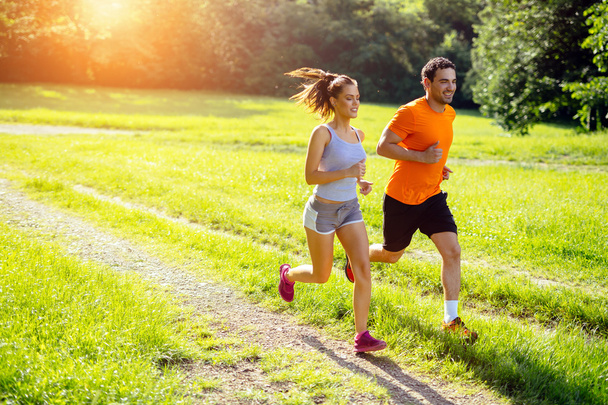 Athletic couple jogging in nature - Zdjęcie, obraz