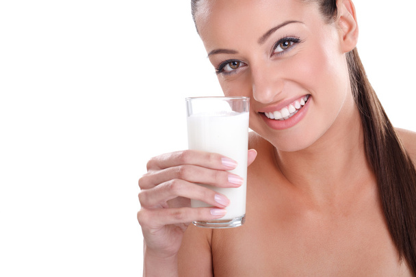 ガラスのミルクと幸せと笑顔の美しい若い女性. - 写真・画像