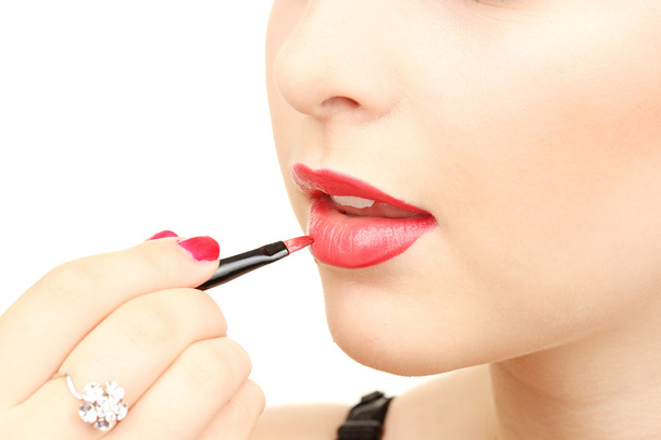 Beautiful woman applying lip gloss - Fotoğraf, Görsel