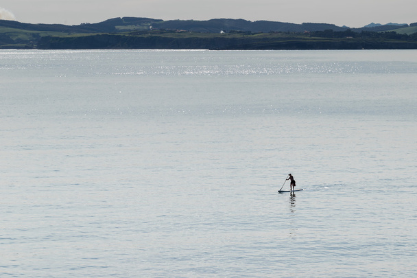 Człowiek praktykuje surf padle  - Zdjęcie, obraz