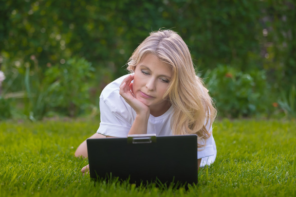 Pretty woman on the grass with notebook - Zdjęcie, obraz