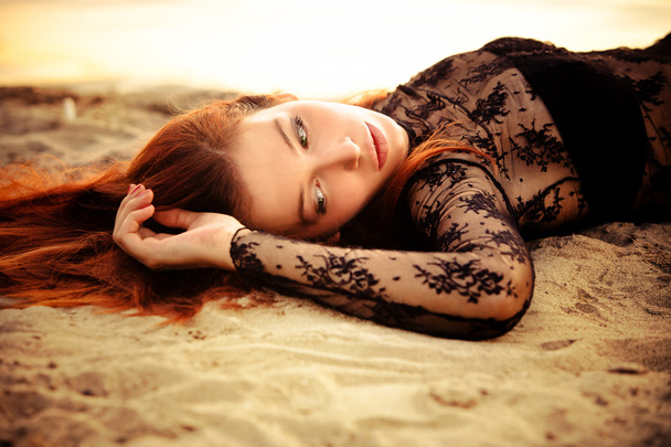 redhead vrouw op zand - Foto, afbeelding