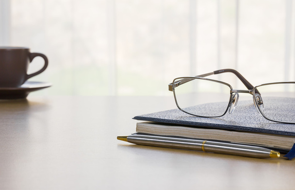 Óculos e livro na mesa
 - Foto, Imagem