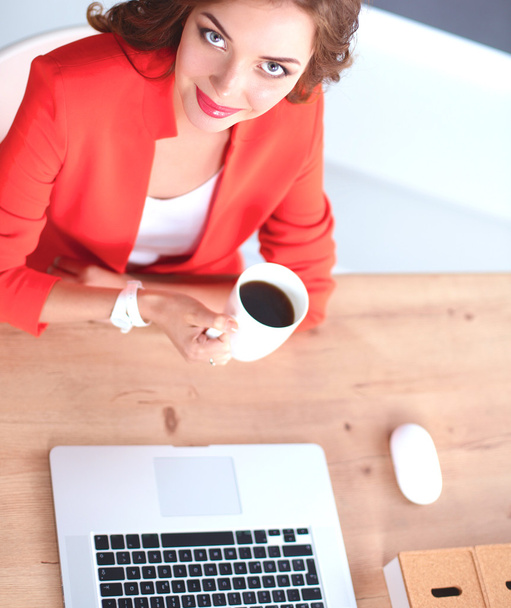 Mujer atractiva sentada en el escritorio en la oficina, trabajando con el ordenador portátil - Foto, imagen