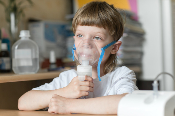 child holds a mask vapor inhaler - Φωτογραφία, εικόνα
