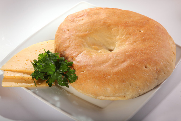 хлеб пита на белой тарелке с ломтиками сыра
 - Фото, изображение