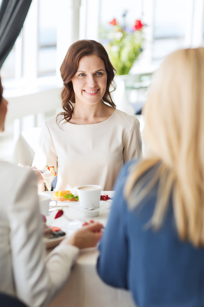 women eating dessert and talking at restaurant - Photo, image
