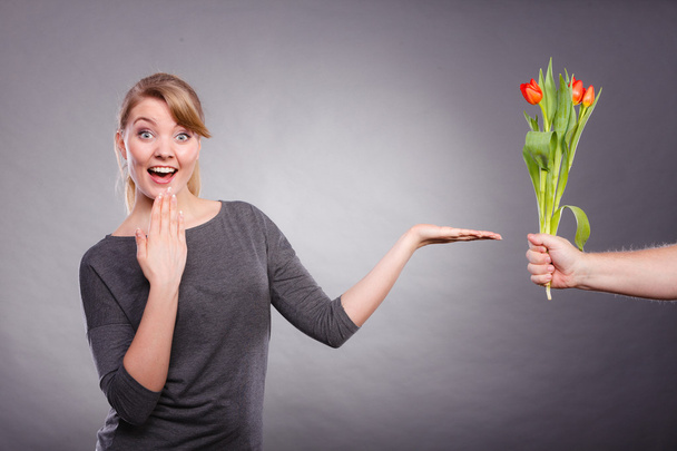Woman gets bouquet of tulips from man. - Zdjęcie, obraz