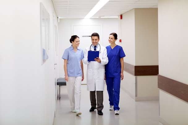 group of smiling medics at hospital with clipboard - Фото, изображение