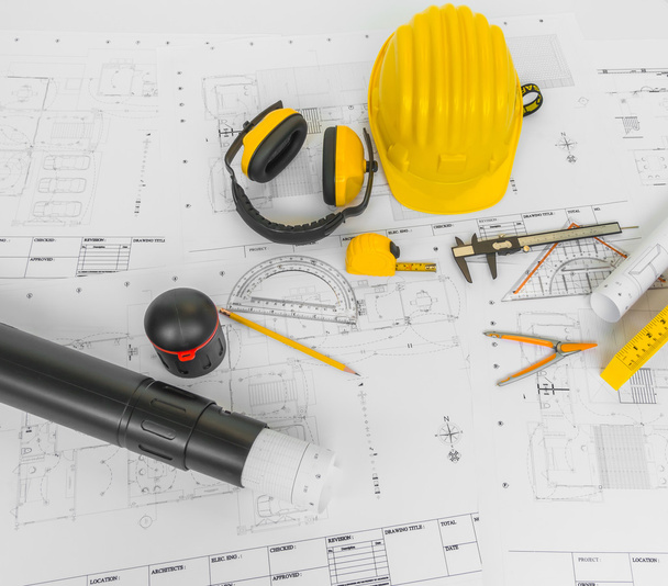 Planos de construção com capacete amarelo e ferramentas de desenho em bluep
 - Foto, Imagem