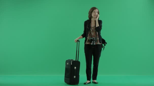 female tourist with camera stands talking on the phone - Materiał filmowy, wideo