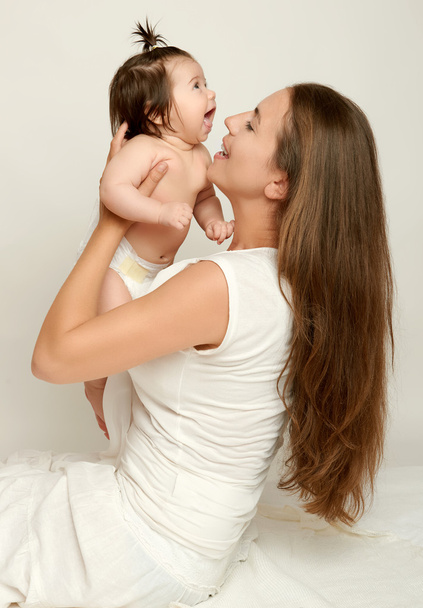 Mamá lanza bebé y beso, jugar y divertirse
 - Foto, imagen