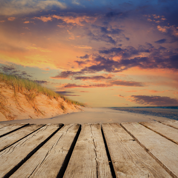 Закат на пляже и пустой деревянный стол на палубе. Готовы к монтажу
.  - Фото, изображение