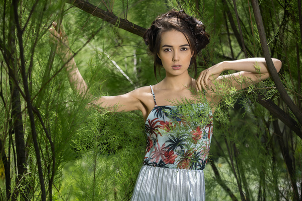  girl in a dress stands between trees - Foto, imagen