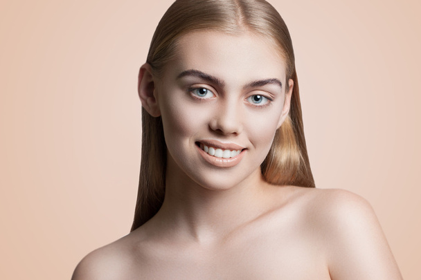Nahaufnahme Porträt einer jungen attraktiven Frau mit wunderschönem Make-up. Blonde Haare, blaue Augen, schönes Lächeln. Archivfotos auf beigem Hintergrund - Foto, Bild