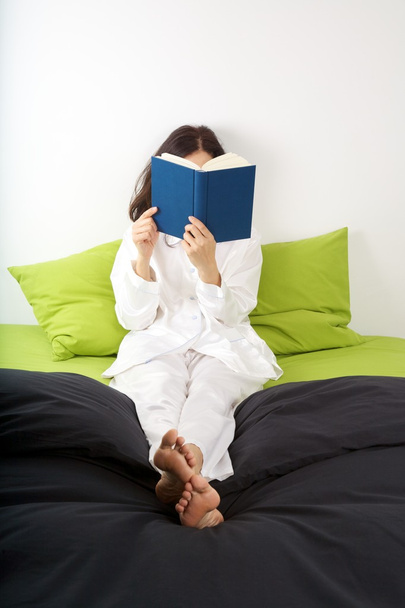 Reading on green bed - Foto, afbeelding