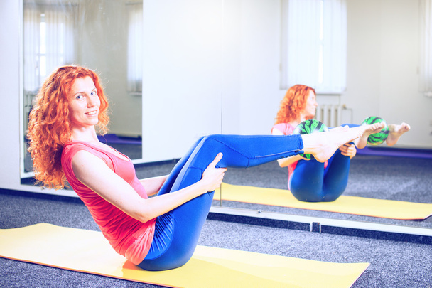 νεαρή γυναικεία εκπαιδευτή κάνει pilates ασκήσεις στη Σπόρτ - Φωτογραφία, εικόνα