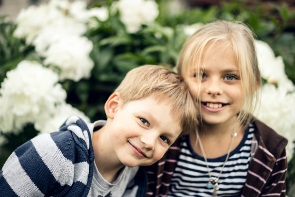 Beautiful blond girl and adorable boy looking at the camera and smiling. - Photo, Image
